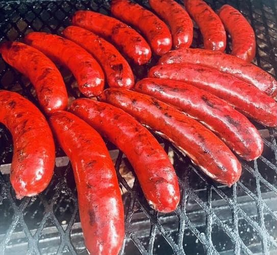 Smoked sausage links on the pit grate