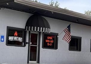 The Smokin' Mike's Meats storefront with its black awning and flag